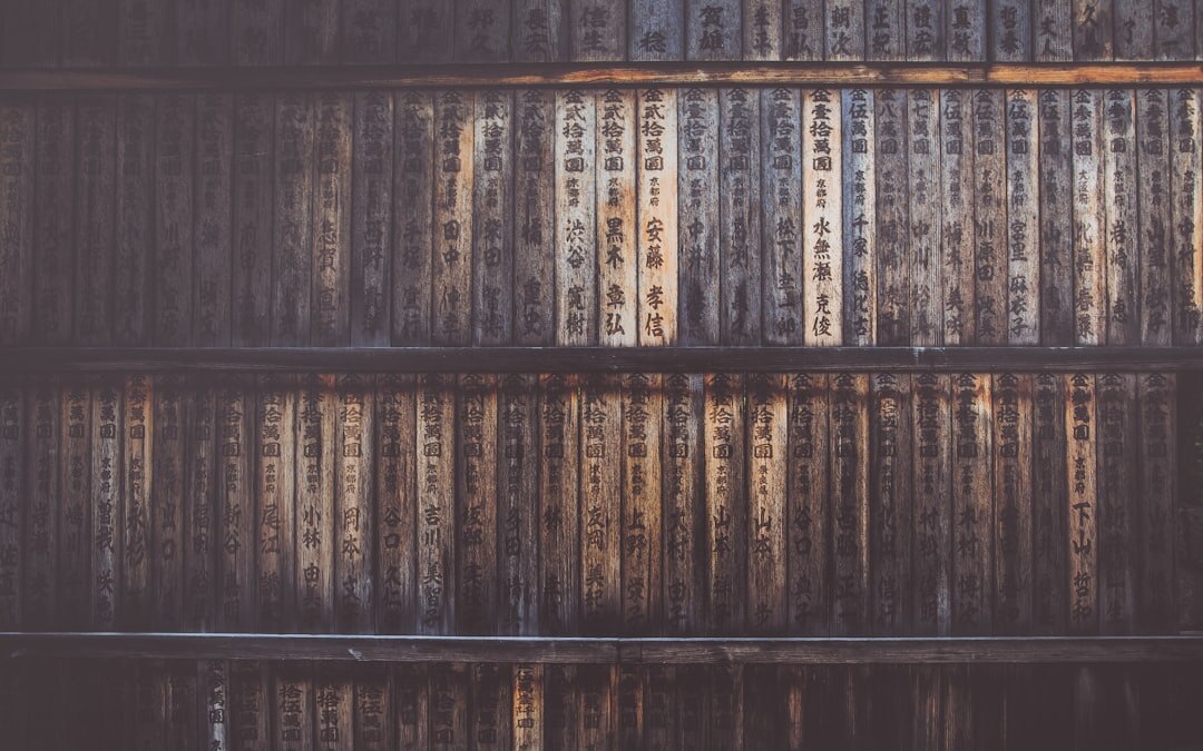 Old wooden library shelves filled with worn books in warm light